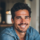 Homme souriant en chemise bleue.